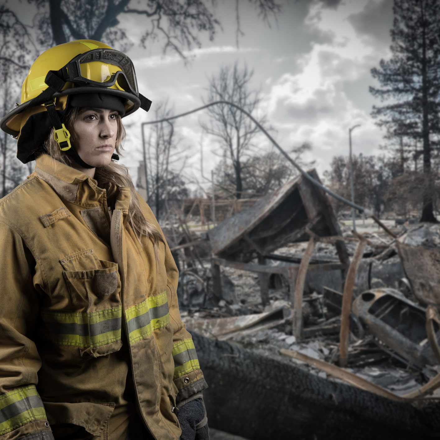 California firefighter by Coffey Park neighborhood after wildfire destroyed homes in the neighborhood ++composite. Background image also taken by photographer++